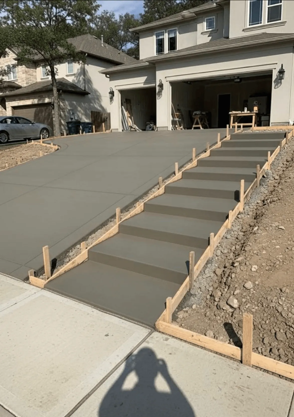 Finished concrete driveway with integrated staircase pour in Austin, TX