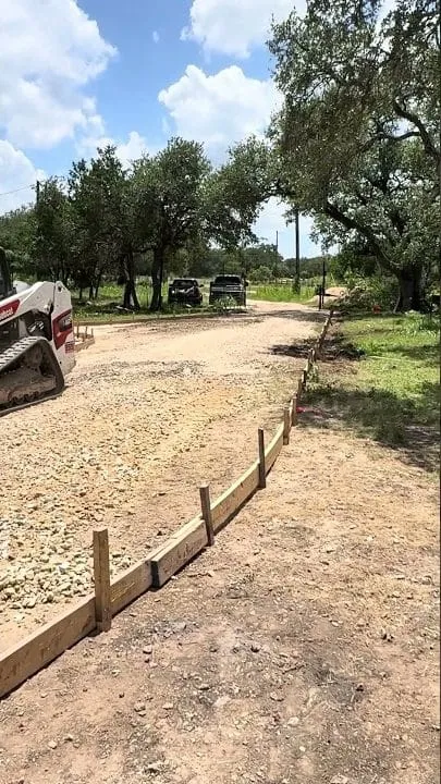 Skid-steer grading the base for the San Marcos driveway pour
